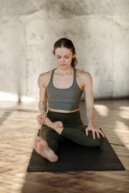 Woman performing a gentle yoga stretch in a warmly lit room with terracotta tones.